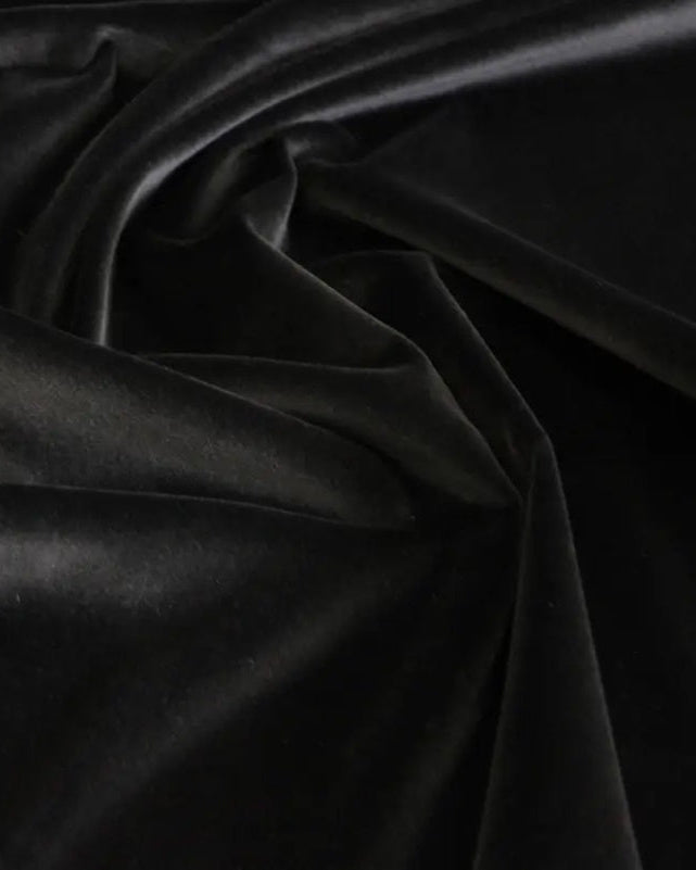 Black velvet fabric draped in soft folds, showing a smooth, lustrous texture.