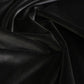 Black velvet fabric draped in soft folds, showing a smooth, lustrous texture.