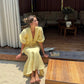 Butter yellow linen set with a relaxed tie front top and flowing midi skirt.
