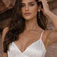 Woman in a white button front silk dress with a rocky background