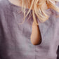 Close-up of a person wearing a textured lavender garment 