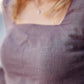 Close-up of a person wearing a textured lavender top