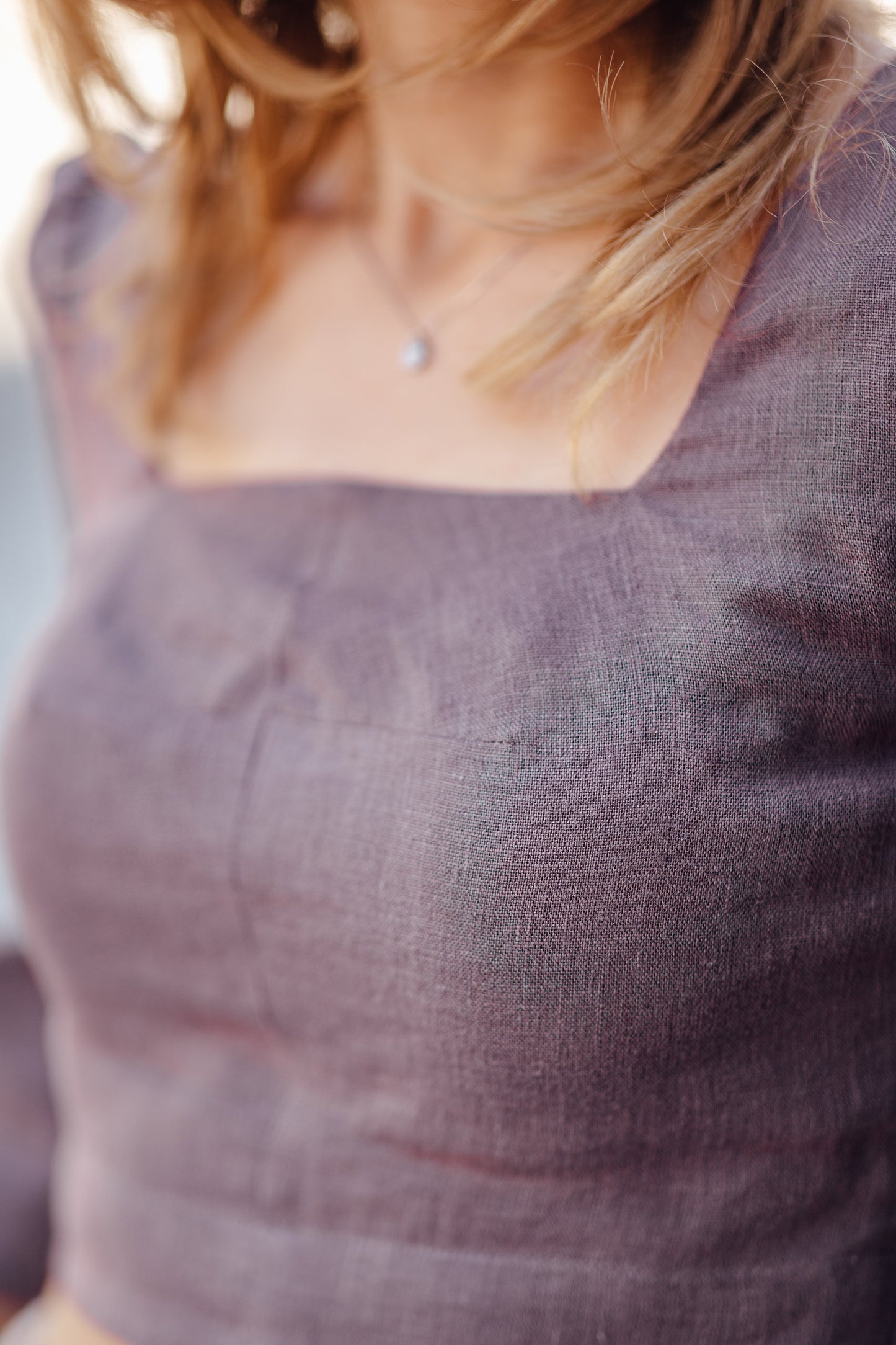 Close-up of a person wearing a textured lavender top