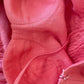 Close up of coral linen corset dress showing natural linen texture and construction details