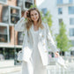 Front view of a beige double-breasted linen blazer with peak lapels and structured shoulders