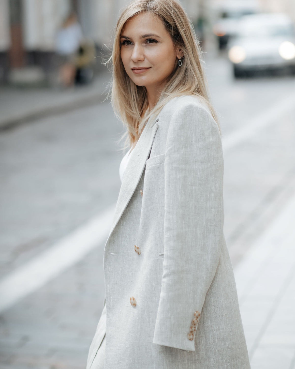 Back view of a beige linen blazer showing its straight relaxed silhouette