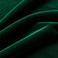Close-up of green velvet fabric arranged in soft folds, showing its smooth surface and subtle sheen.