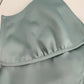 Close-up of a light gray swimsuit top on a beige background