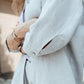 Close-up of grey linen shirt with pearl shell buttons and textured fabric