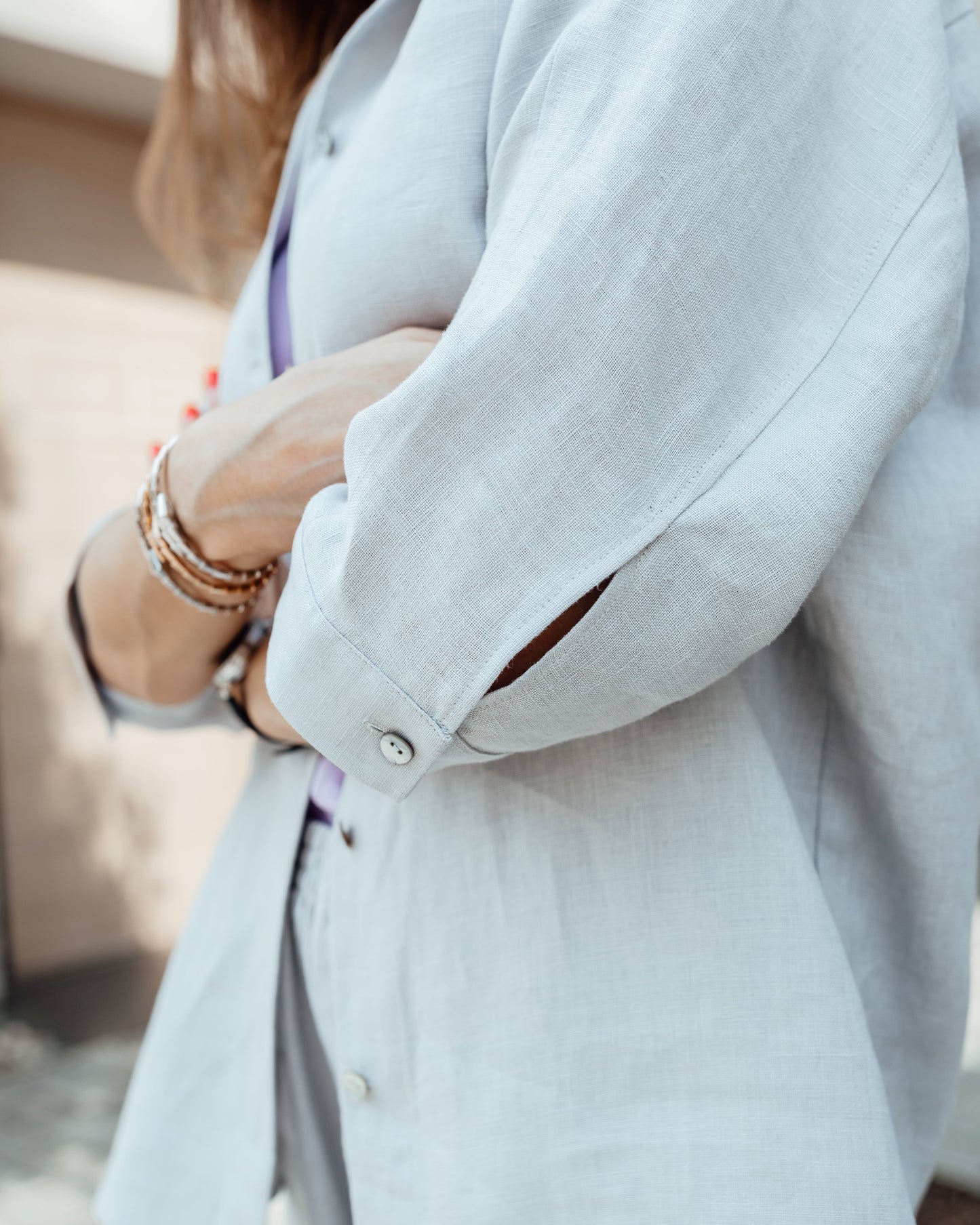 Close-up of grey linen shirt with pearl shell buttons and textured fabric