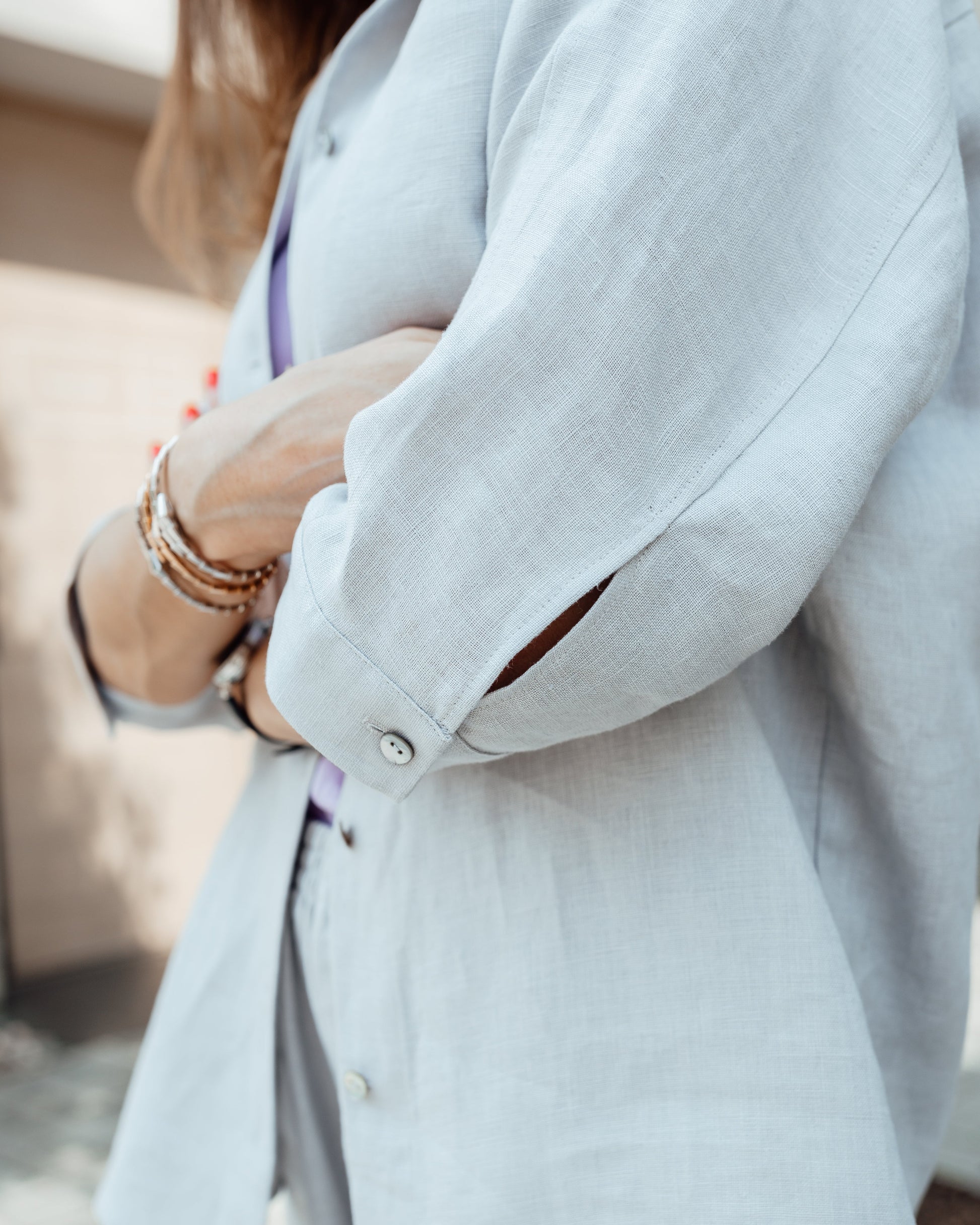 Close-up of grey linen shirt with pearl shell buttons and textured fabric