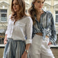Two models wearing a striped linen long sleeve relaxed shirt in a casual setting