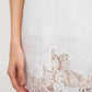 Close-up of a white lace garment on a plain background