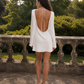 Open back bridal mini dress with low draped back and tie detail.