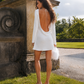 Back view of a silk mini wedding dress featuring a dramatic open back and flared sleeves.