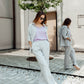 Woman wearing a grey linen two-piece set with relaxed trousers and a raglan sleeve shirt