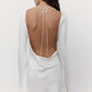 Studio back view of a silk mini wedding dress with an open back and tie closure.