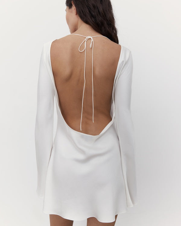 Studio back view of a silk mini wedding dress with an open back and tie closure.
