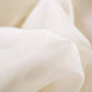 Close-up of white fabric with a soft texture on a beige background