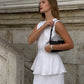 Close-up of white linen bias cut skirt and peplum top