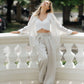 Woman wearing beige wide-leg linen trousers with a high waist and front pleats, shown in full view