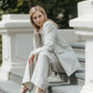 Woman styling anatural linen blazer with matching trousers and a white top