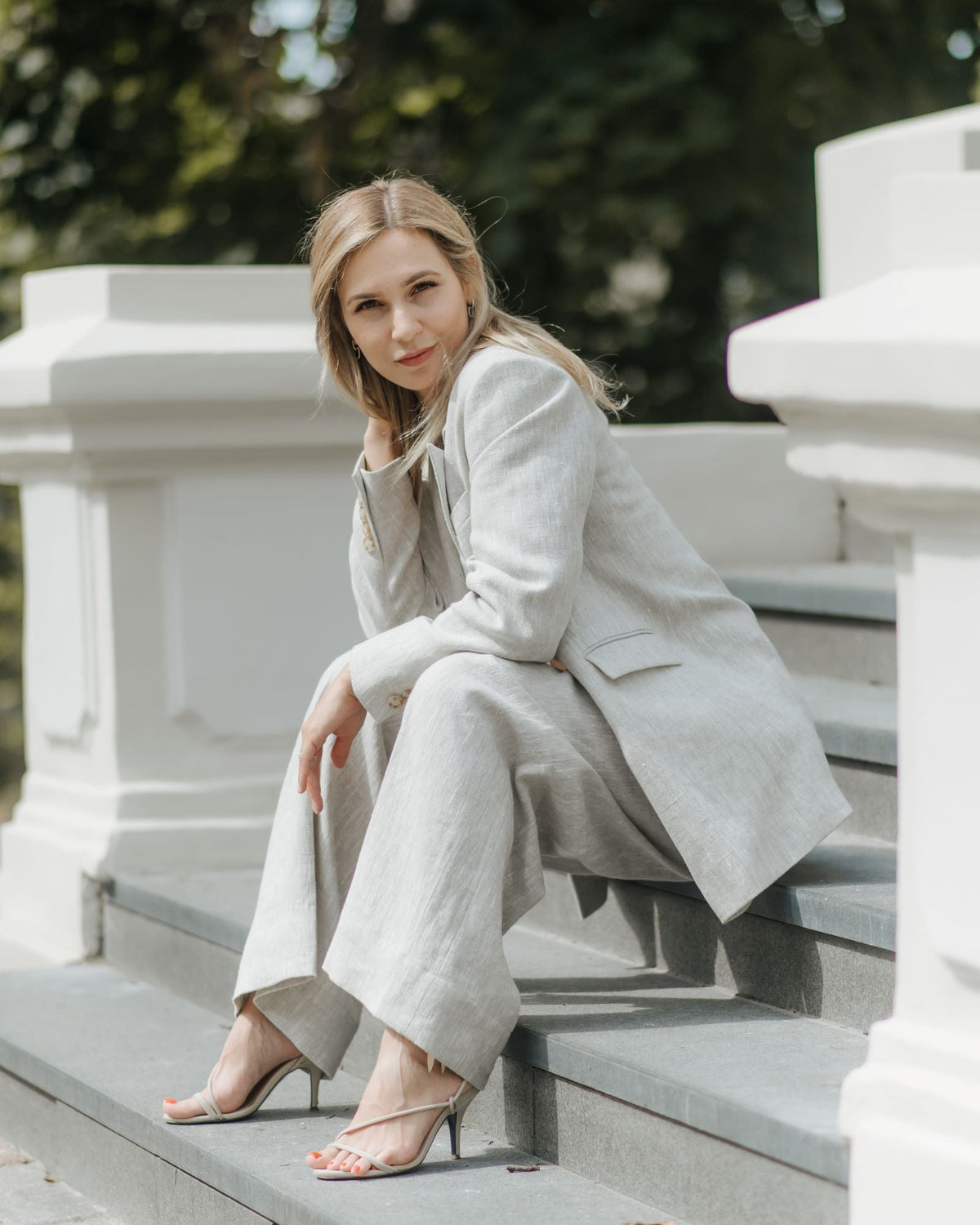 Woman styling anatural linen blazer with matching trousers and a white top