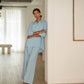 Woman in a light blue outfit standing in a modern interior setting