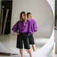 Purple cotton ascot tie-neck blouse with long bow ties, sculptural shoulder draping and voluminous sleeves