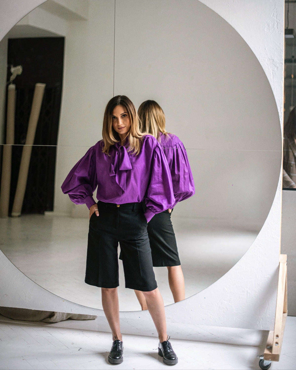 Purple cotton ascot tie-neck blouse with long bow ties, sculptural shoulder draping and voluminous sleeves