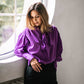 Purple tie-neck blouse with voluminous sleeves and extra-long structured French cuffs