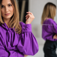 Purple ascot blouse with voluminous sleeves and folded French cuffs with pearl cufflinks