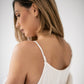Close up back view of a woman wearing an ivory silk slip dress with delicate shoulder straps