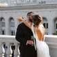 Bride wearing an ivory silk maxi dress standing with her partner.