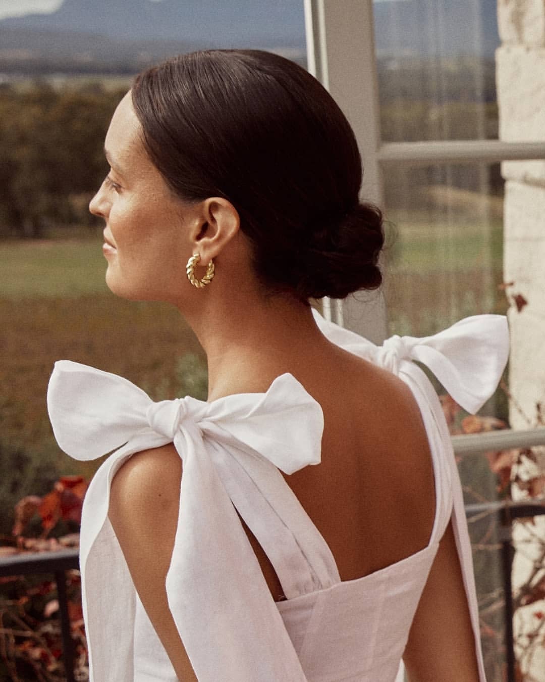 Close up of white linen shoulder bows and open back detail