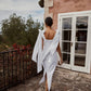 Back view of a white linen midi dress with back slit and long tie bows