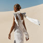 Back view of a white linen midi dress with long tie shoulder bows
